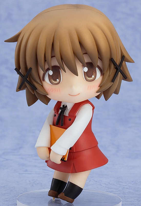 a nendoroid of yuno. she's a short girl with short, mousey-brown hair adorned with two X-shaped hair pins, and brown eyes. she's wearing her school uniform, a red top with a white dress shirt and small black ribbon around her neck beneath, a red box-pleated skirt, black socks, and brown loafers. she's holding a sketchbook underhanded, close to her waist.