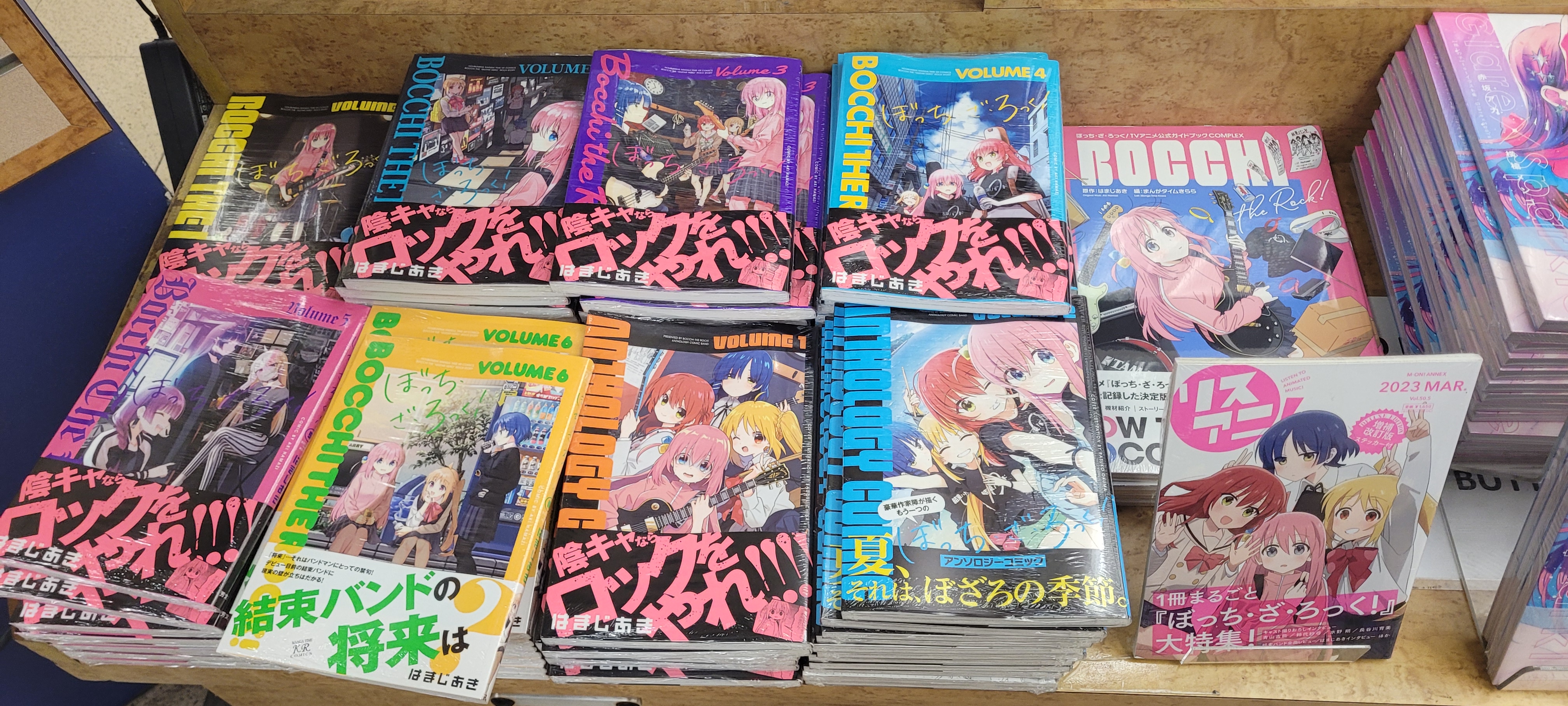 a photo of a retail display filled with various Bocchi the Rock books. these include all volumes of the manga currently out, as well as a volume of LisAni, an anime music magazine, published in March 2023, featuring the main cast on the cover.