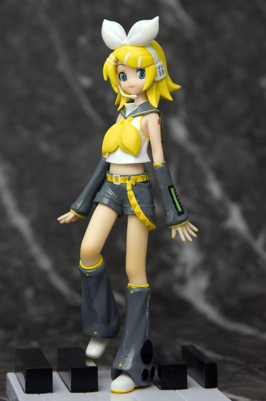 an early prize figure of rin, released in 2008. she is standing on the keys of a piano.