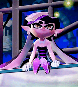 a gif of in-game footage, with callie sitting on the edge of the top of her stage truck and swinging her legs